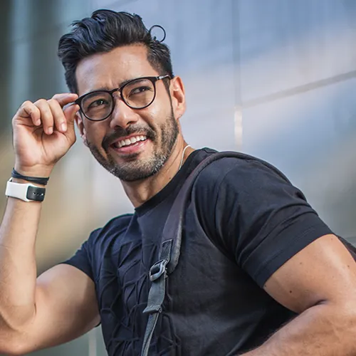 Man smiling back adjusting his glasses